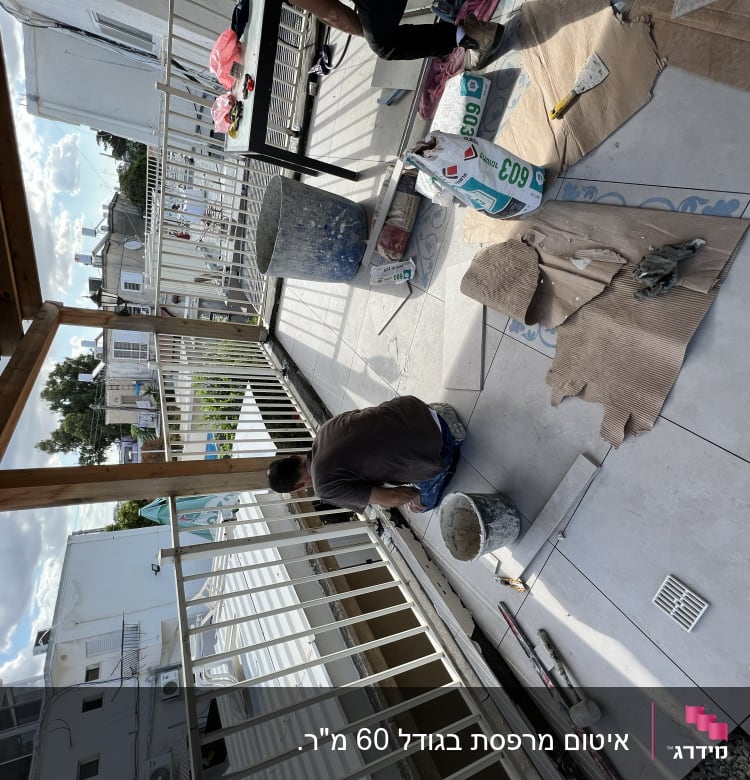 אדם עובד על איטום מרפסת עם חומרי בניין